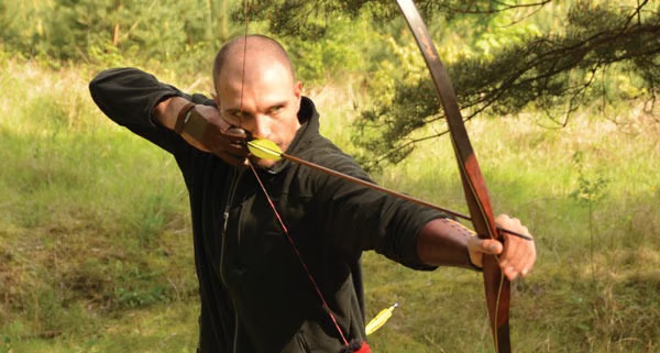Traditional archer drawing a bow in training